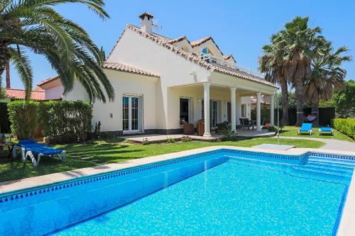 a villa with a swimming pool in front of a house at Villa Lujo Olivanova Golf MET in Oliva