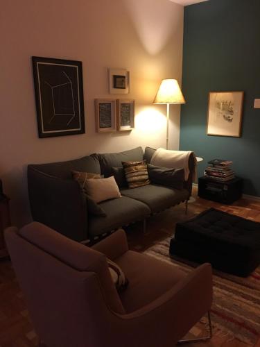 a living room with a couch and a lamp at Bom Retiro, literature & coffee in São Paulo