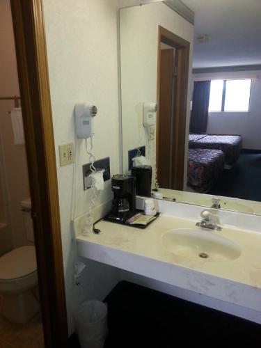 a bathroom with a sink and a mirror at Days Inn by Wyndham Maumee/Toledo in Maumee