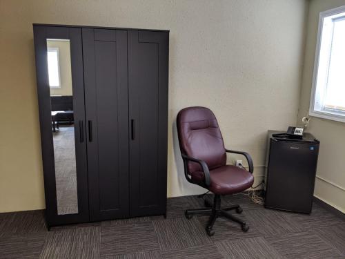 a office with a chair and a mirror and a door at The Cavalier Inn in Winnipeg