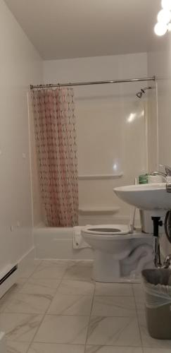 a white bathroom with a toilet and a sink at The Tallwood Motel in Wells