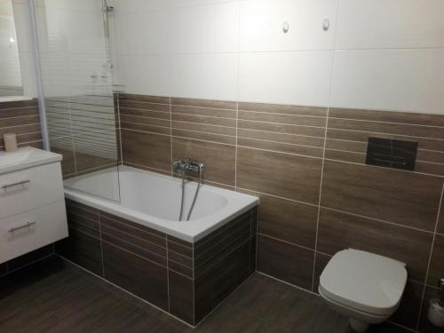 a bathroom with a bath tub and a toilet at Apartamet Marzenie 7 - Opole in Opole