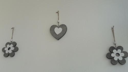a heart and two flowers hanging on a wall at Residenza Leonarda in Vado Ligure