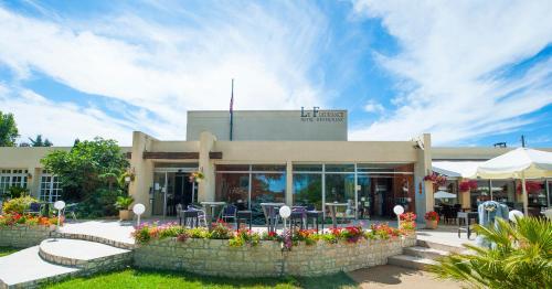 a restaurant with flowers in front of a building at Logis Hôtel & Restaurant Le Fleurance in Fleurance