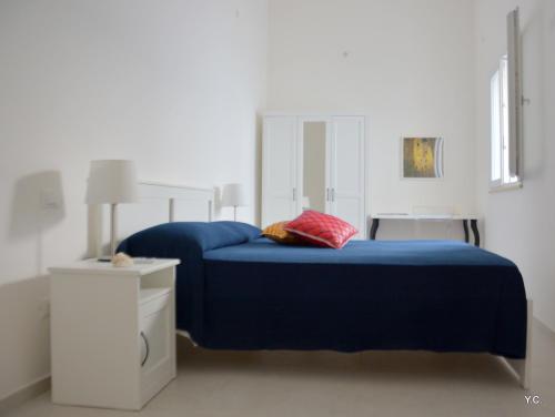 ein Schlafzimmer mit einem blauen Bett und einem roten Kissen in der Unterkunft Casa Euribia in Augusta