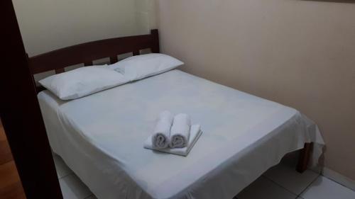 a white bed with two towels on top of it at Pousada da Orla in Salinópolis