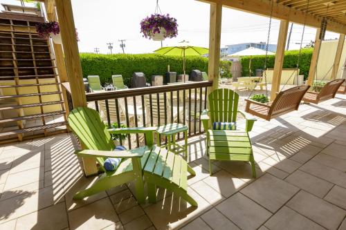 a porch with green chairs and an umbrella at The Ocean Resort Inn in Montauk
