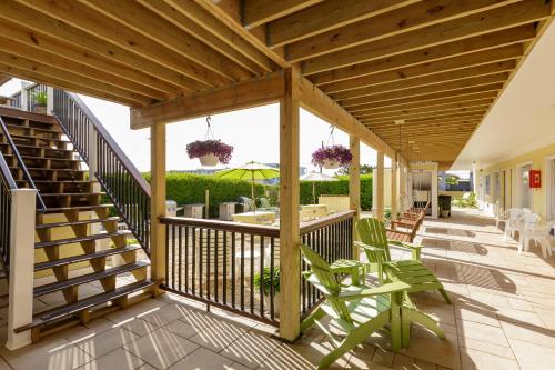 a wooden deck with chairs and an umbrella at The Ocean Resort Inn in Montauk