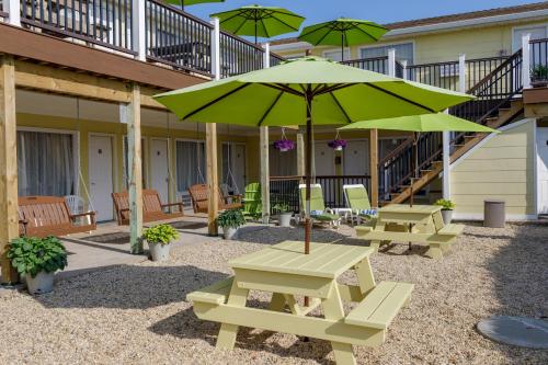 a patio with picnic tables and a green umbrella at The Ocean Resort Inn in Montauk
