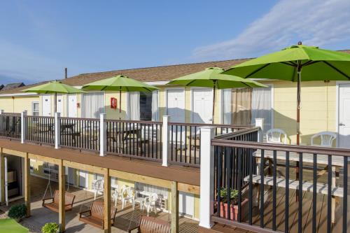 a deck with tables and chairs and umbrellas at The Ocean Resort Inn in Montauk