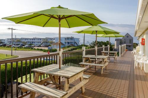 a patio with tables and umbrellas on a balcony at The Ocean Resort Inn in Montauk