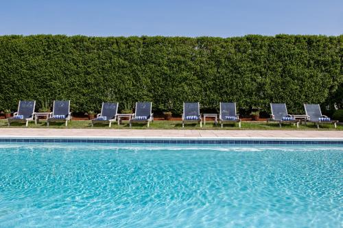 a row of chairs sitting next to a swimming pool at The Ocean Resort Inn in Montauk