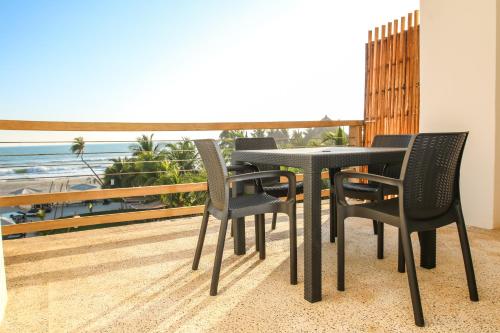 a table and chairs on a balcony with a view of the ocean at Mishol Bodas Hotel & Beach Club Acapulco Diamante in Acapulco
