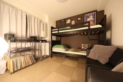 a room with two bunk beds and a couch at Casa HANA in Tokyo