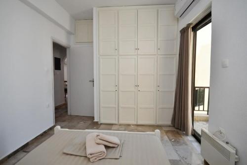 um quarto com um armário branco com toalhas numa cama em Central flat, 300m from the beach em Lerápetra
