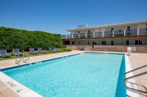 a swimming pool in front of a hotel at Aqualina Inn Montauk in Montauk