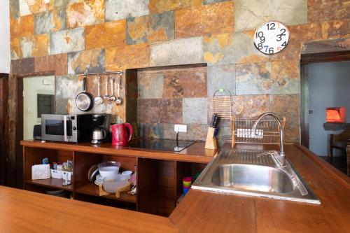 サンタ・ウルスラにあるTypical Canary Houseのキッチン(シンク、壁掛け時計付)