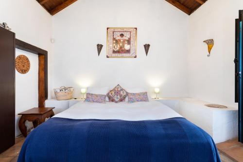 a bedroom with a large bed with a blue blanket at Typical Canary House in Santa Úrsula