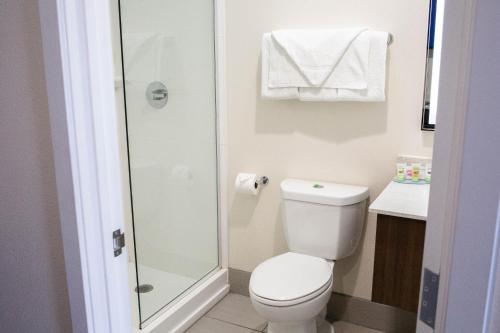 a small bathroom with a toilet and a shower at Palace Inn El Paso in El Paso