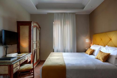 a hotel room with a large bed and a desk at Montespina Park Hotel in Naples