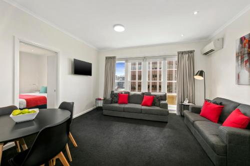 a living room with a couch and a table at Quest Savoy in Hobart