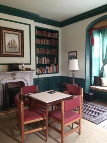 une salle à manger avec une table, des chaises et une cheminée dans l'établissement Antique Mansion B & B, à Rutland