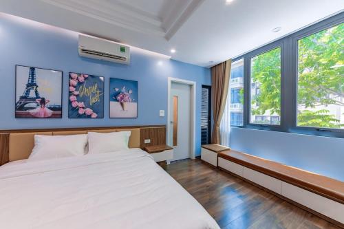 EVEREST HOTEL في هانوي: غرفة نوم بسرير ابيض وجدران زرقاء