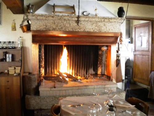 a fireplace in a room with a table in front of it at Locanda Al Centrale in Caprino Veronese