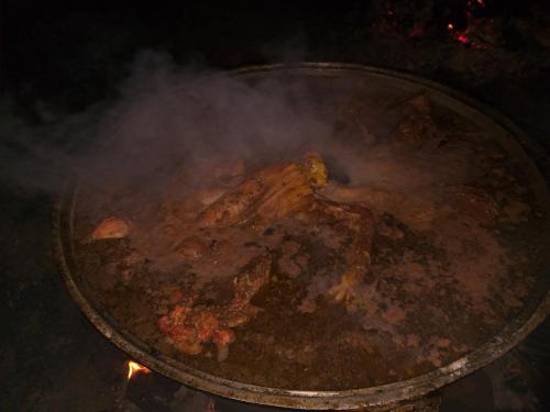 a pan of food cooking on a stove with smoke at EcoUlan in Kochkor