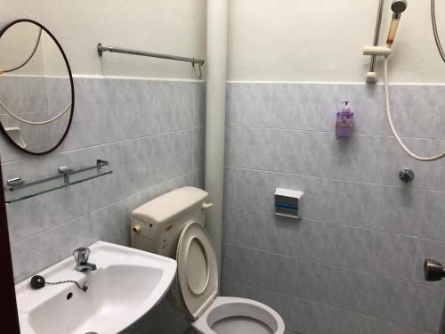 ein Badezimmer mit einem WC, einem Waschbecken und einem Spiegel in der Unterkunft New Casa De Monte in Malakka