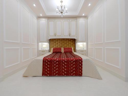 a white bedroom with a bed with a red blanket at Сказочно волшебная квартира Соломенском районе Добробут in Kyiv