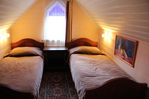 two beds in a small room with a window at Villa Florio in Jūrmala
