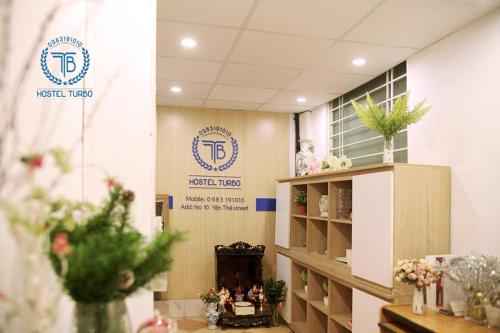 a room with two signs on the wall and flowers at HOSTEL TURBO in Hanoi