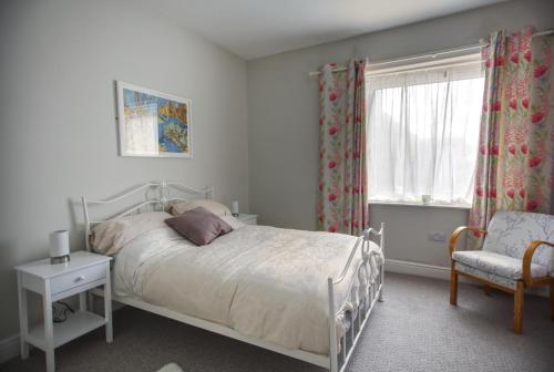 a bedroom with a bed and a chair and a window at Seashore in Hastings