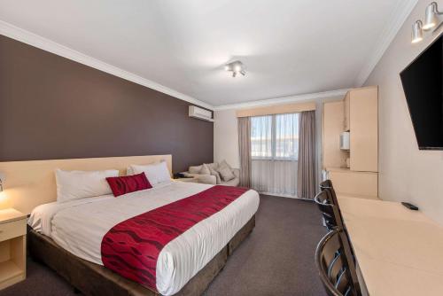 a hotel room with a large bed and a television at Comfort Inn Moree in Moree