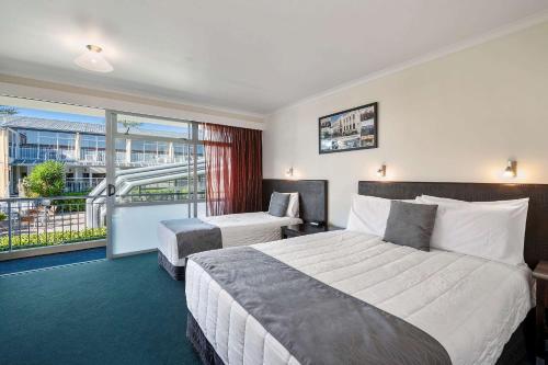 um quarto de hotel com duas camas e uma varanda em Quality Inn Napier em Napier