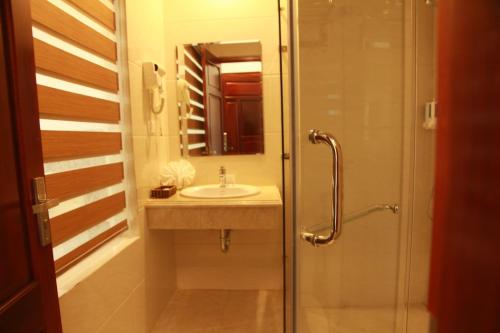 a bathroom with a sink and a shower at Khách sạn Hải Quân - The Marine Hotel in Ha Long