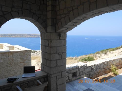 a view of the ocean from a stone wall at Stonehouse villas with breathtaking view in Sitia