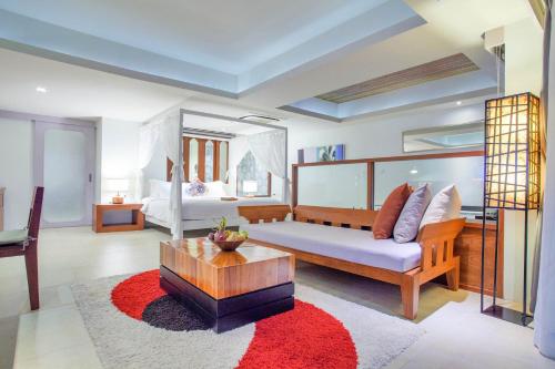 a living room with a bed and a table at Zenmaya Oceanfront Phuket, Trademark Collection by Wyndham in Patong Beach