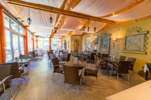 restauracja ze stołami, krzesłami i oknami w obiekcie Egidiwirt Murau w mieście Murau