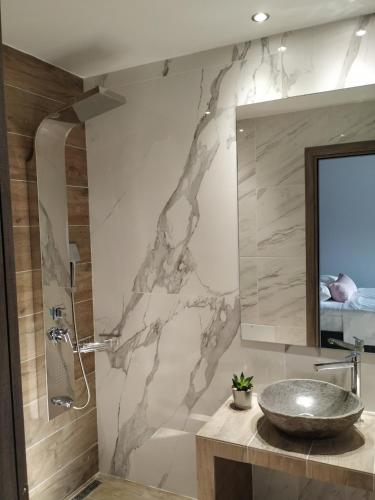 a bathroom with a sink and a mirror at Home Sweet Home in Ammoudia