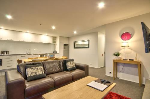 un soggiorno con un divano e un tavolo di Highview Central a Queenstown