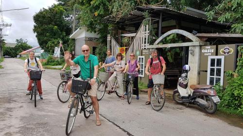 un grupo de personas montando bicicletas por una calle en Saikaew Resort, en Chiang Rai