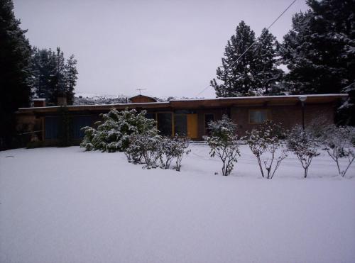 a house with a yard covered in snow at Hosteria La Chacra in Esquel