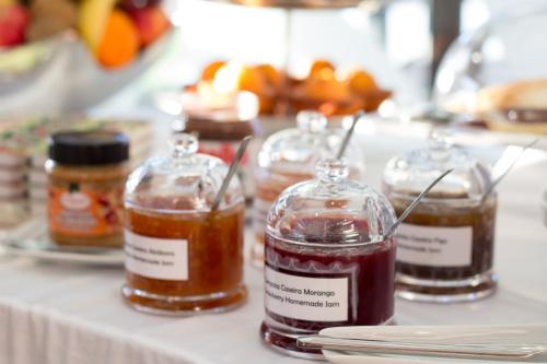 a table with four jars of honey on it at Hotel Portas De Santa Rita in Ermesinde