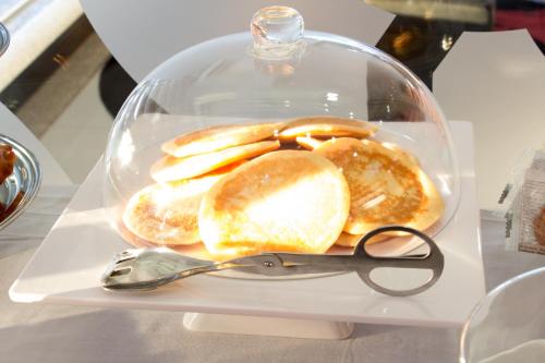 a plastic container filled with pancakes and a pair of scissors at Hotel Portas De Santa Rita in Ermesinde
