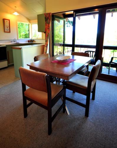 a dining room with a wooden table and chairs at Greenacres Alpine Chalets & Villas in Hanmer Springs