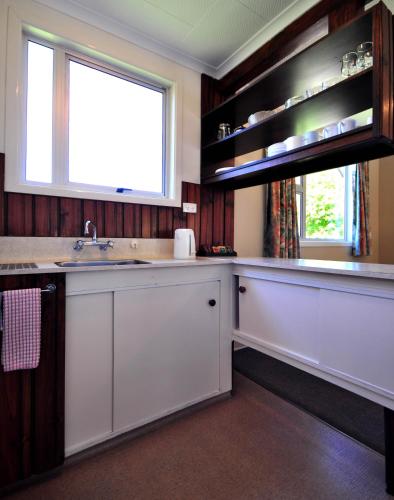 a kitchen with a sink and a window at Greenacres Alpine Chalets & Villas in Hanmer Springs