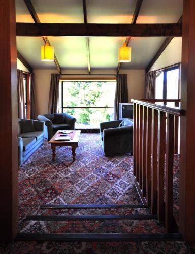 a living room with couches and a table at Greenacres Alpine Chalets & Villas in Hanmer Springs