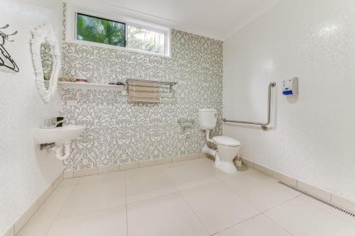 a bathroom with a toilet and a sink at Coral Inn Boutique Hotel in Yeppoon